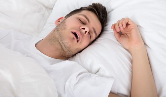 Ronflement de la langue : causes et solutions pour ne plus dormir sur le dos